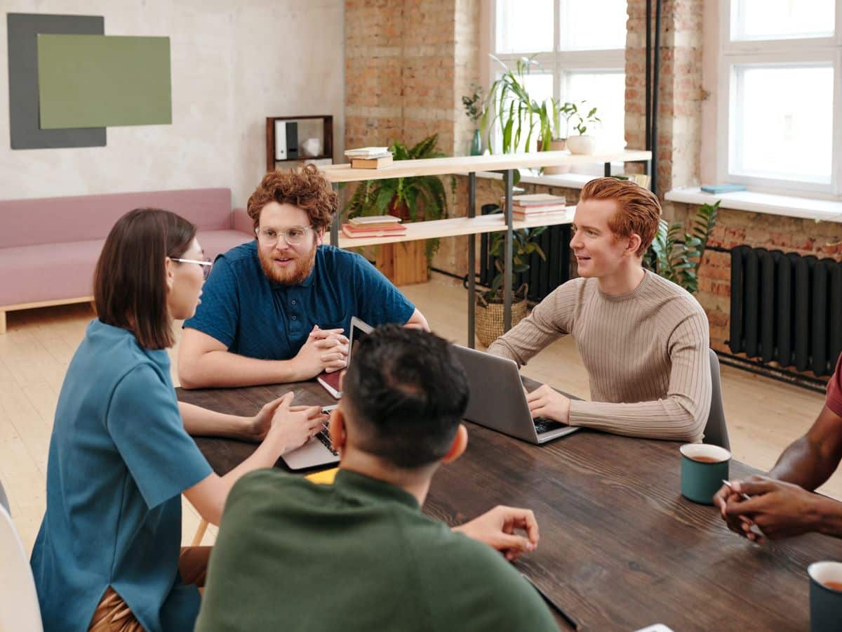 a group of professionals sit around a table at a brainstorming meeting