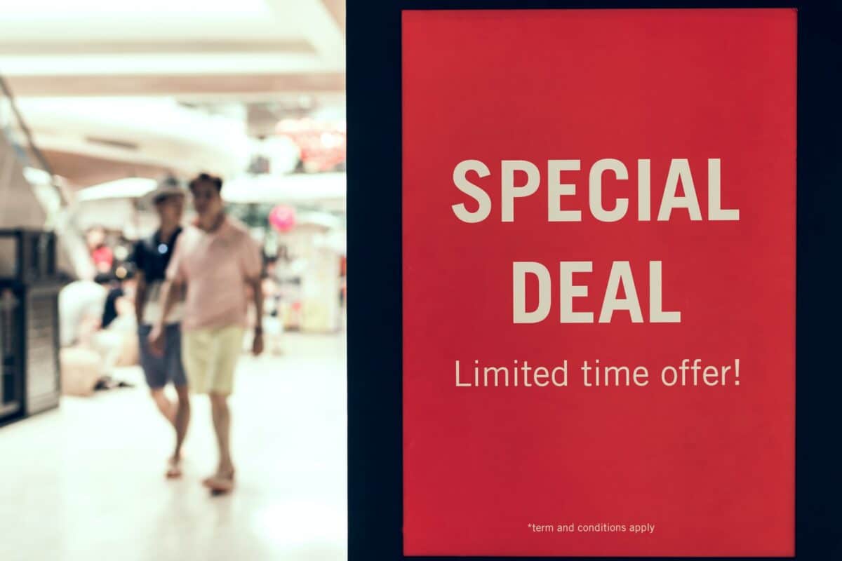 A large red sign reads SPECIAL DEAL Limited time offer! in white text, urging shoppers to act fast on this video CTA. In the brightly lit background, two people walk through a busy indoor shopping mall.