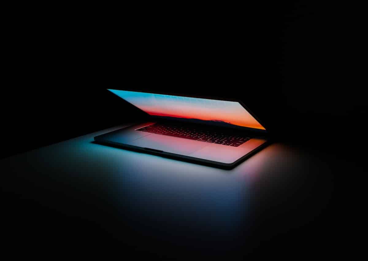 A laptop opening up in darkness