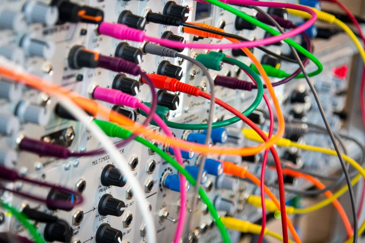 Close-up of a modular synthesizer with colorful cables creating a complex network of connections, ideal for showcasing electronic music equipment in ads for those seeking where to advertise innovative audio gear.