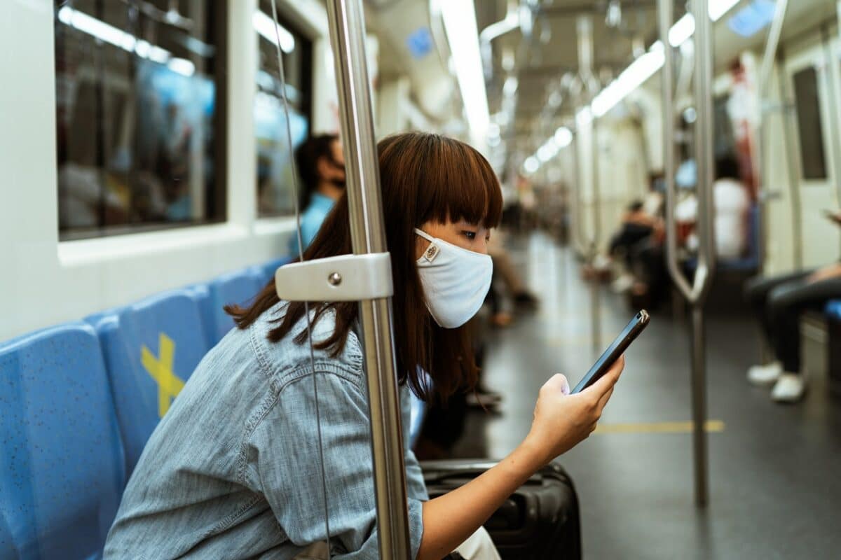 Woman looking at her phone while sitting on the subway