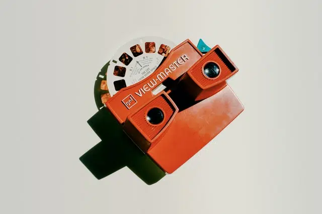 a view-master toy lying on a white surface. The toy casts a dark shadow.