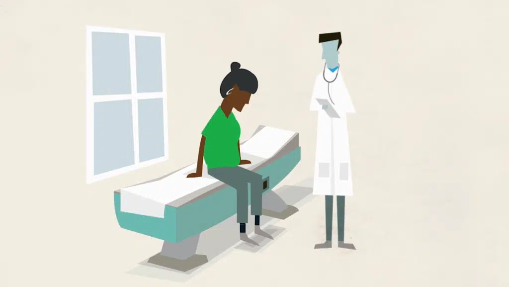 screenshot from patient journey video, shows a black female character sitting on an exam table looking dejected. A blue male doctor character stands nearby