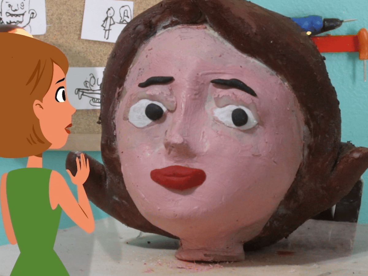 An animated woman sculpts a giant clay replica of her head for use in stop motion animation