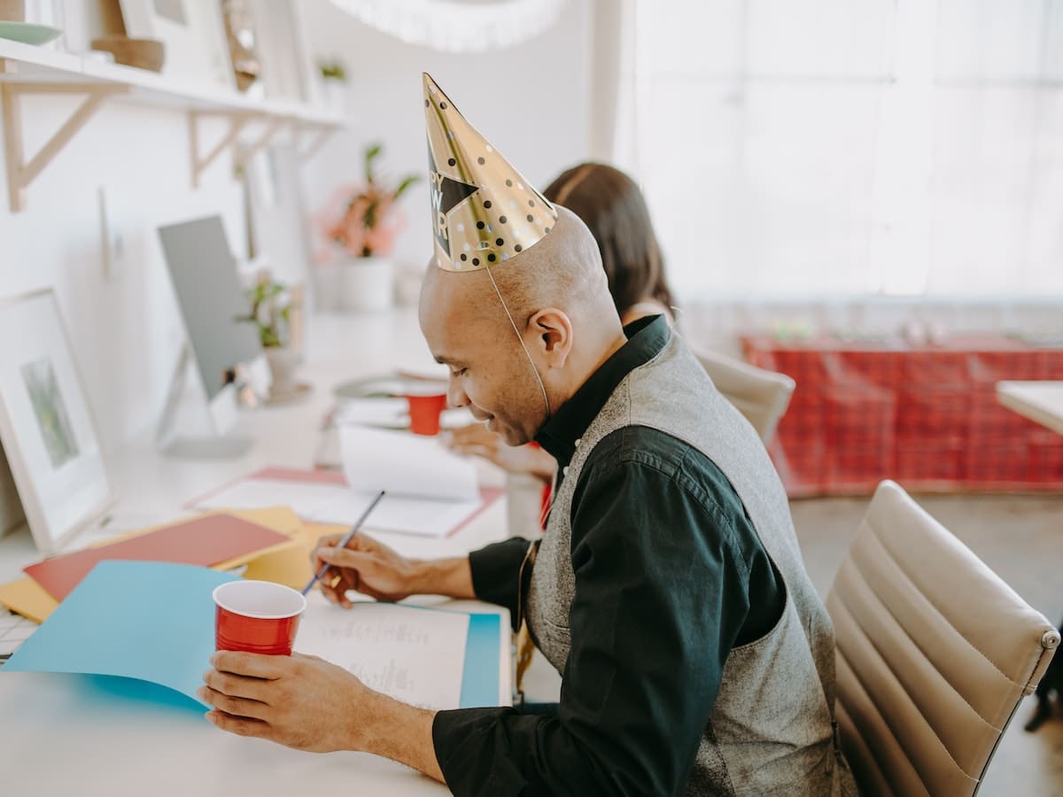 office employees work on B2B marketing during the holidays while wearing party hats