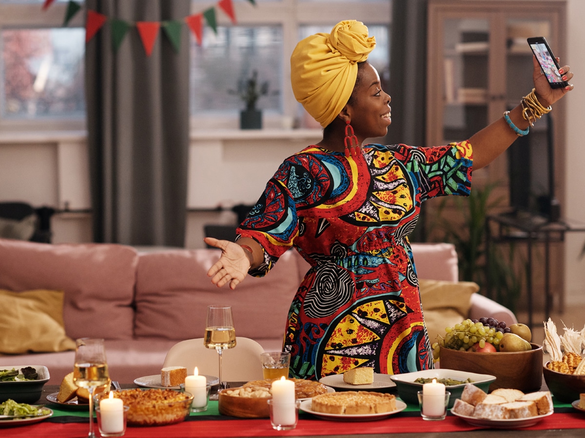woman dressed in traditional African garments takes a selfie during the holidays