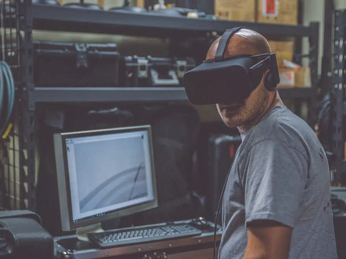 man uses virtual reality at work while standing in front of a computer